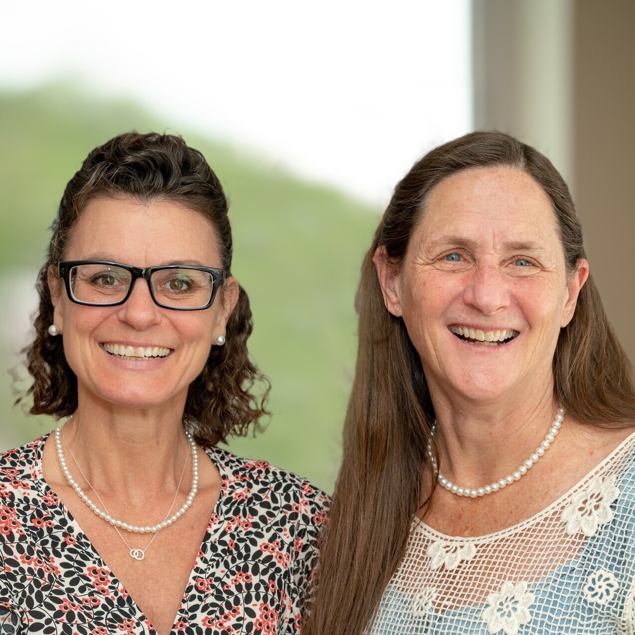 Two women standing next to each other smiling