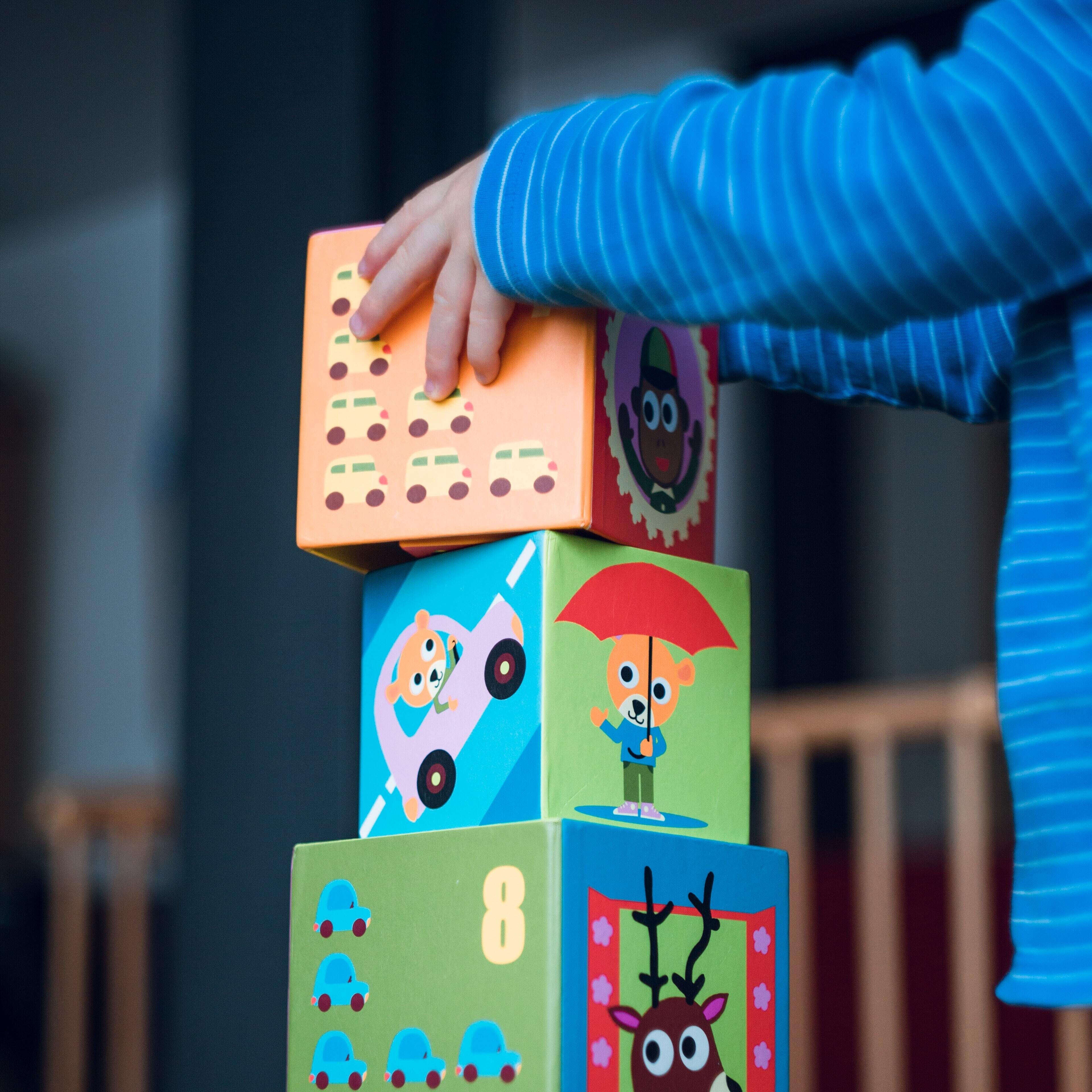 A child placing colorful blocks vertically 