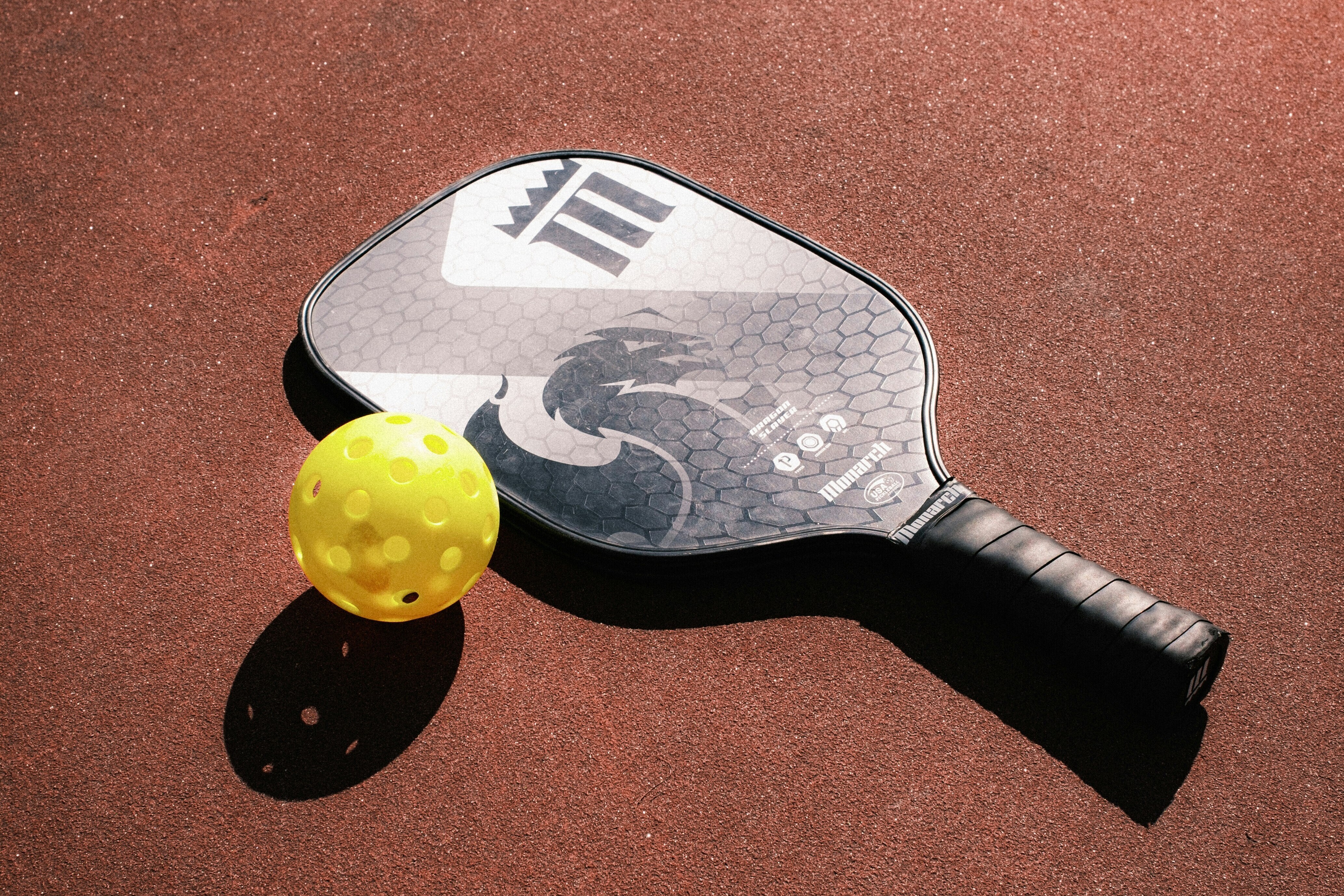 Pickleball racket and ball on court